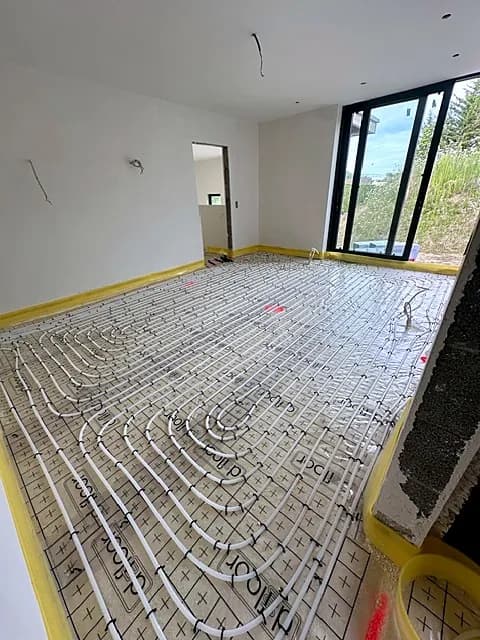 Pièce lumineuse avec tubes de chauffage par le sol sur isolant, bande de rive jaune